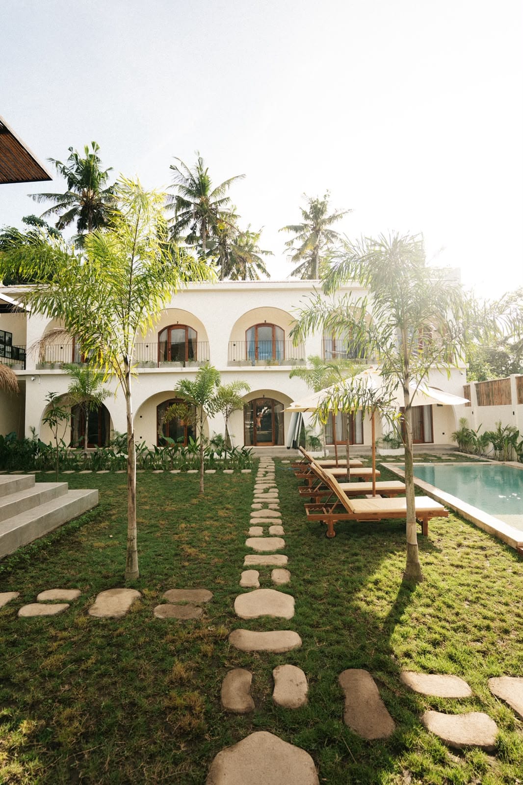 Garden courtyard with stepping stones, palms and the arched rooms