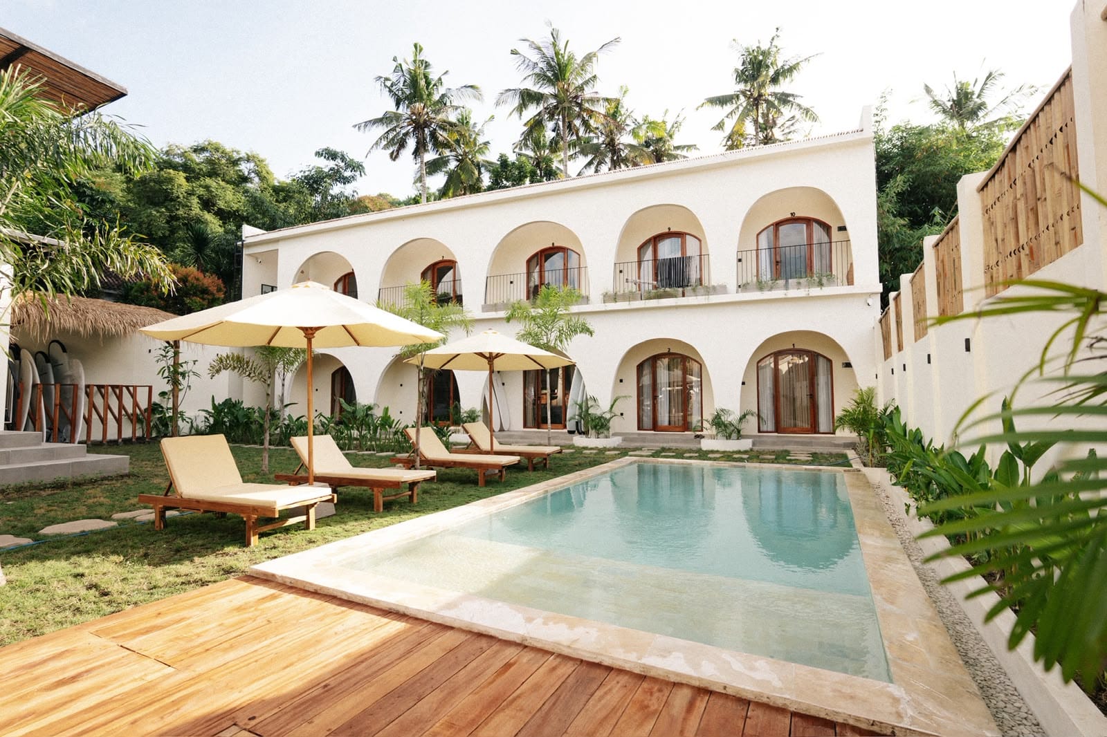 TwinFin: two-storey white arched building, sun loungers and pool